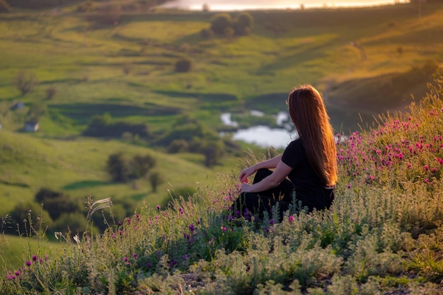 Foto vista trasera de una mujer sentada en el campo