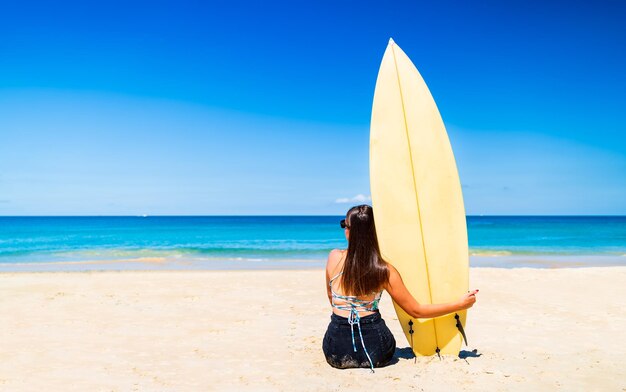 Vista trasera de una mujer sentada en la playa