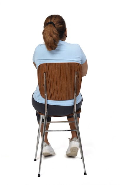 Vista trasera de una mujer sentada sobre fondo blanco,