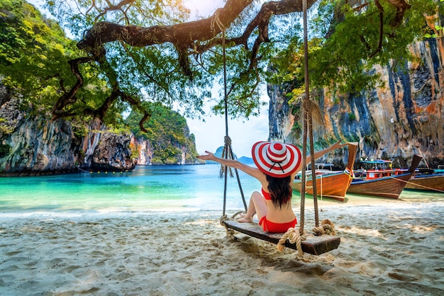 Foto vista trasera de una mujer sentada en un tobogán en la playa