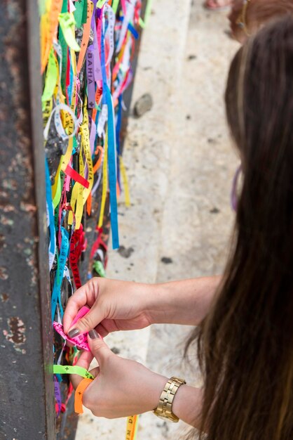 Vista trasera de una mujer sosteniendo una pared multicolor