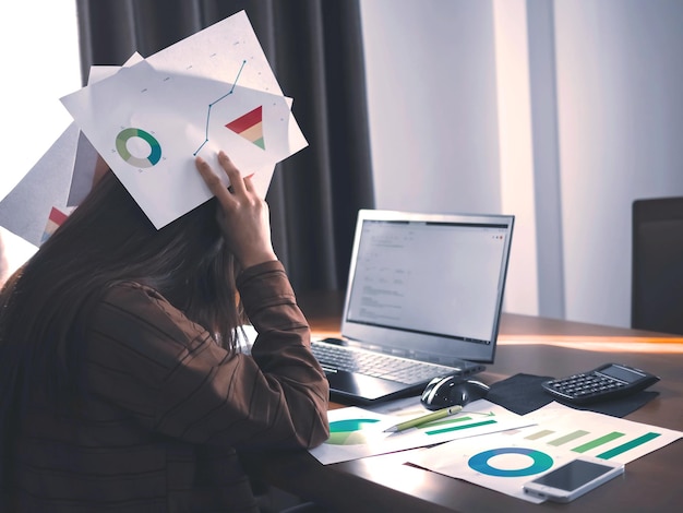 Vista trasera de una mujer usando una computadora portátil en la mesa