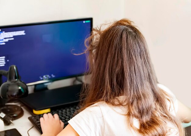 Vista trasera de una mujer usando una computadora portátil