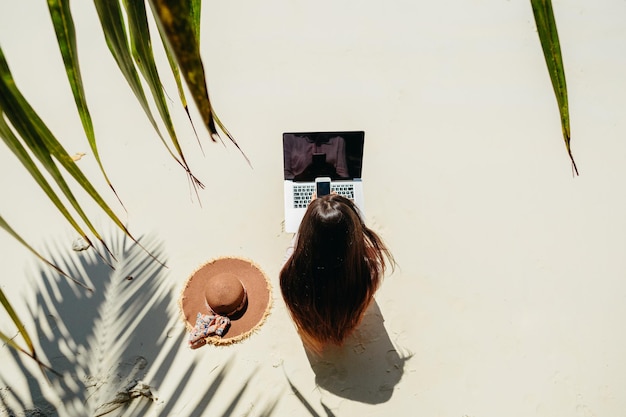 Vista trasera de una mujer usando el teléfono mientras está de pie en la planta