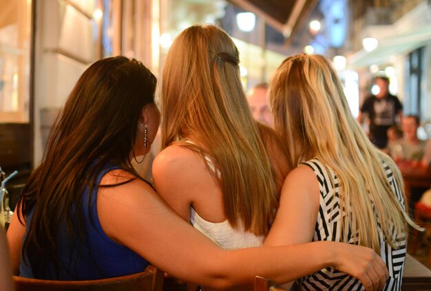 Foto vista trasera de mujeres en un café en la acera