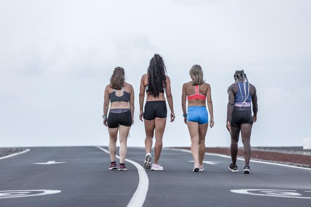 Vista trasera de mujeres caminando contra el cielo