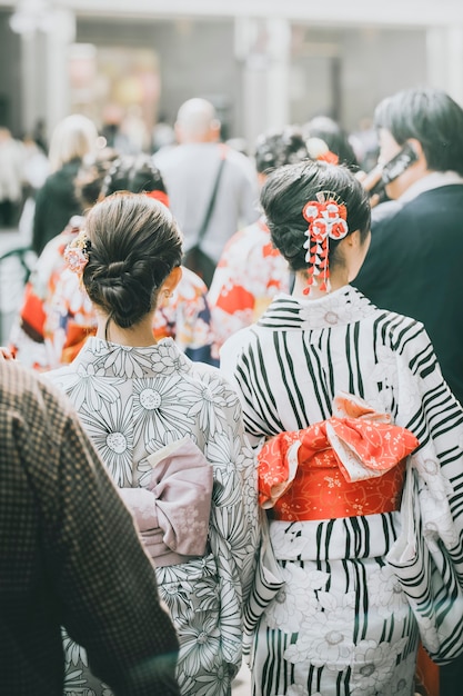 Vista trasera de mujeres japonesas en yukata entre la multitud