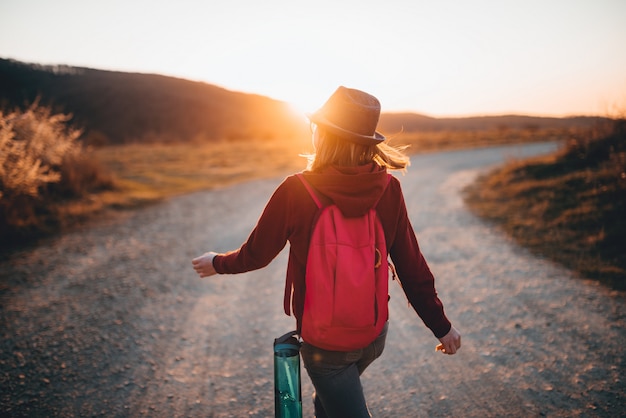 Foto vista trasera de una niña caminando sola durante el atardecer