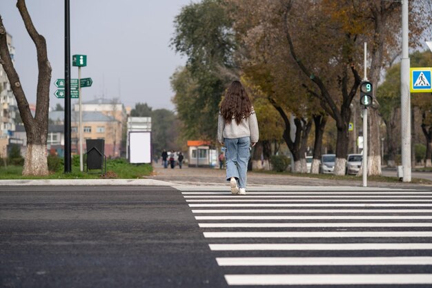 Foto vista trasera de una niña cruzando la carretera