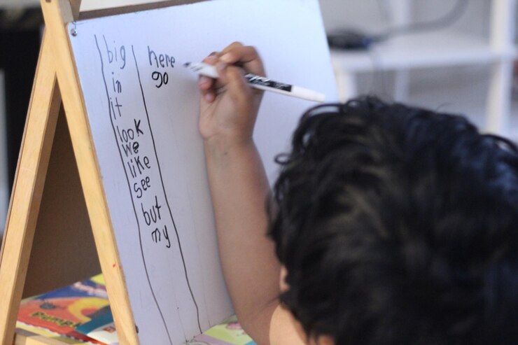 Foto vista trasera de una niña escribiendo a bordo