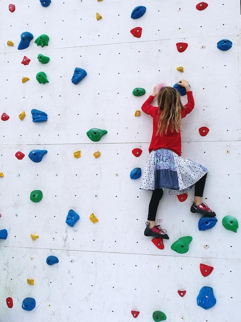 Foto vista trasera de la niña en la pared de escalada