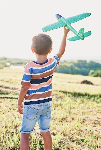 Foto vista trasera del niño con un avión.