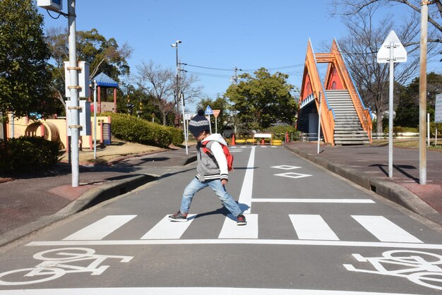 Foto vista trasera de un niño caminando por la carretera