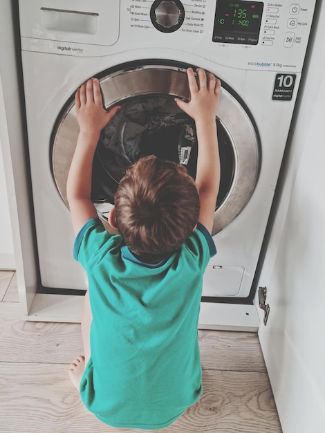 Foto vista trasera del niño en casa