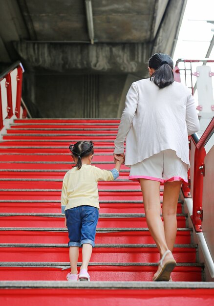 Vista trasera del niño niña caminar con la madre