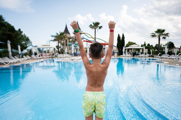 Vista trasera de un niño saltando a la piscina