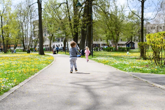 Vista trasera de niños caminando al aire libre en el parque