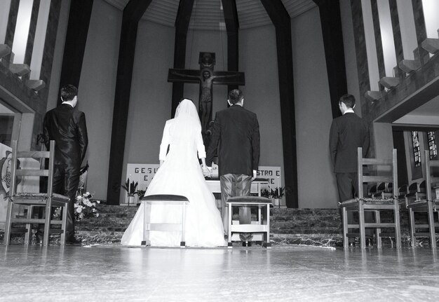 Foto vista trasera de la novia y el novio en la iglesia