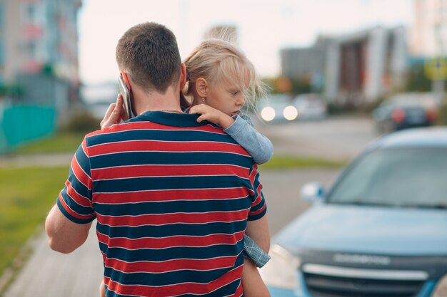 Vista trasera del padre caminando al centro de cuidado infantil con su pequeña hija.