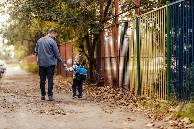 Foto vista trasera de un padre y su hijo en el jardín de infantes