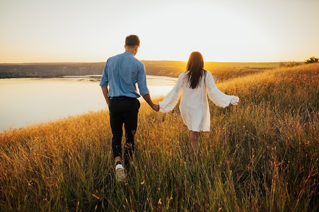 Vista trasera de una pareja caminando y disfrutando del atardecer juntos