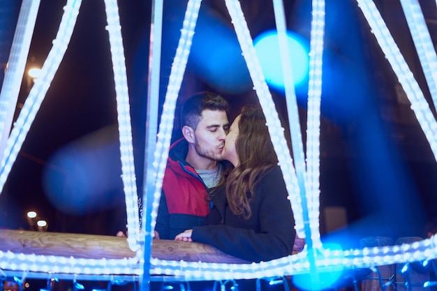 Foto vista trasera de la pareja contra luces iluminadas por la noche