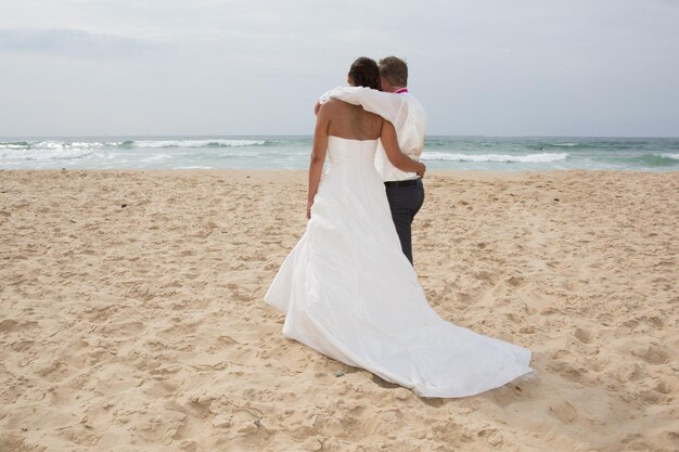 Vista trasera de una pareja joven feliz romántica juntos en la playa