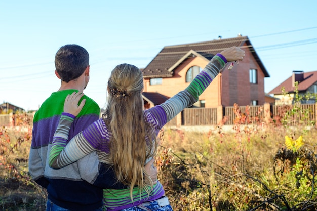 Vista trasera de una pareja joven mirando su nueva casa