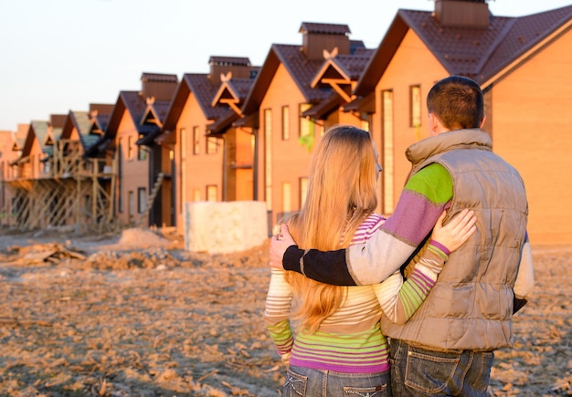 Vista trasera de una pareja joven mirando su nueva casa