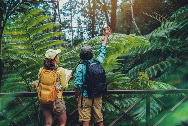 Foto vista trasera de una pareja de pie contra los árboles en el bosque