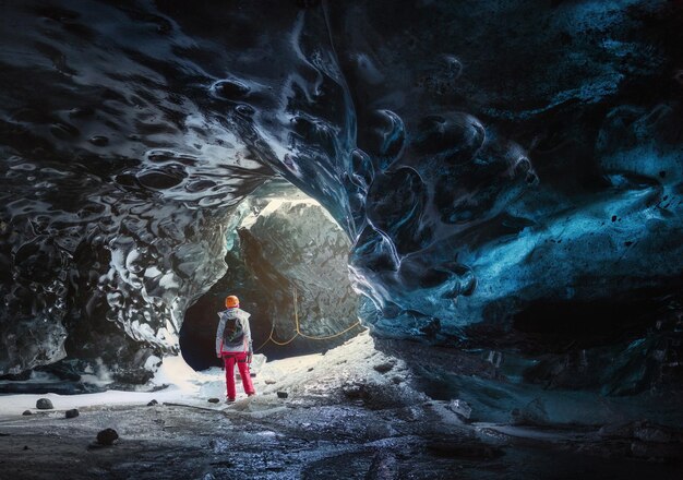 Foto vista trasera de una persona de pie en una cueva de hielo