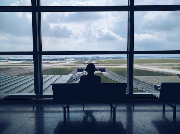 Foto vista trasera de una persona sentada en un aeropuerto