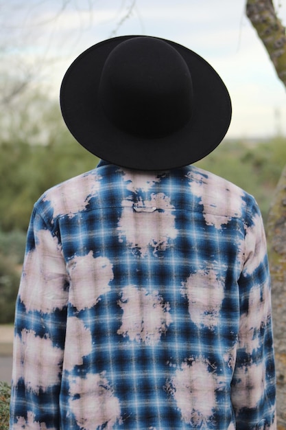 Vista trasera de una persona con sombrero de pie al aire libre