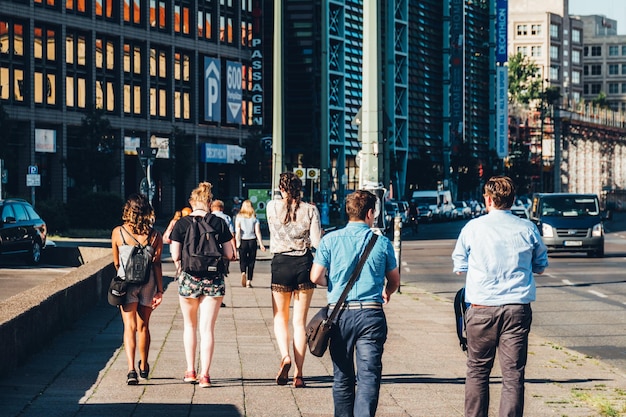 Vista trasera de personas caminando contra edificios en la ciudad