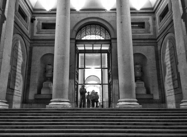 Vista trasera de personas caminando por la escalera de un edificio