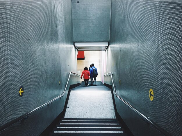 Foto vista trasera de personas en la escalera en el metro