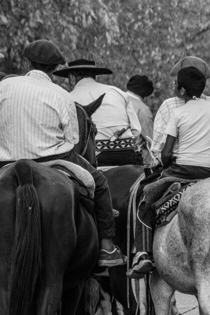 Vista trasera de personas montando a caballo en el bosque