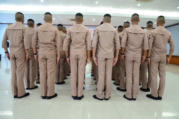 Vista trasera de personas de pie en fila