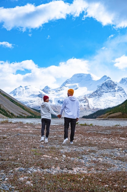 Foto vista trasera de personas de pie en una montaña cubierta de nieve contra el cielo