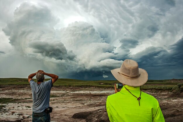 Foto vista trasera de personas de pie en la playa contra el cielo