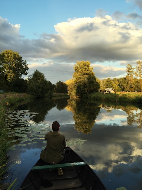 Foto vista trasera de personas relajándose en la orilla del lago