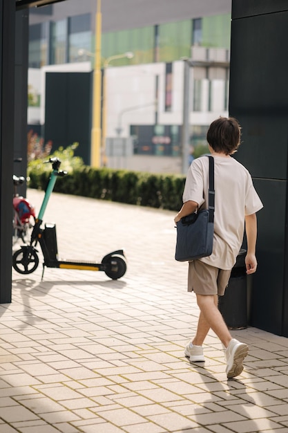 Vista trasera del repartidor va a su scooter eléctrico