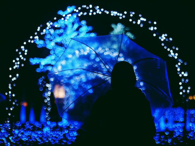 Vista trasera de la silueta del hombre de pie contra la luz iluminada