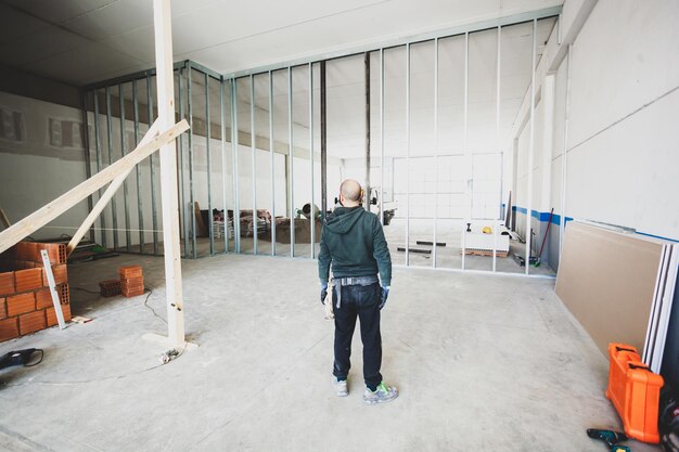 Foto vista trasera de un trabajador de la construcción de pie en el sitio