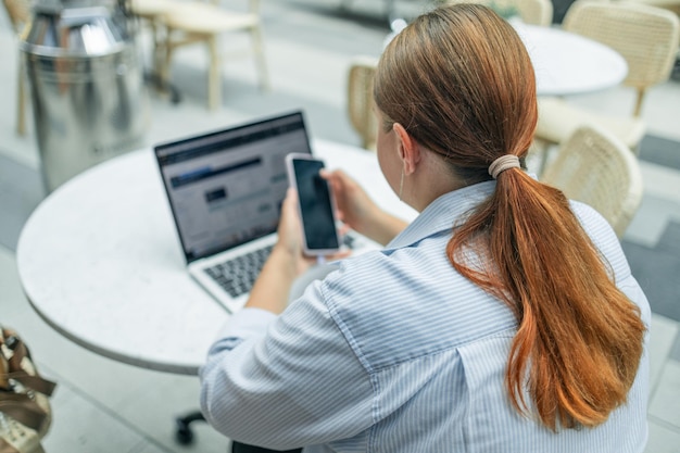 Vista trasera de una trabajadora tiene una conferencia de grupo por cámara web con compañeros de trabajo en una computadora portátil moderna en casa