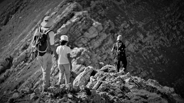 Foto vista trasera de turistas caminando por la montaña