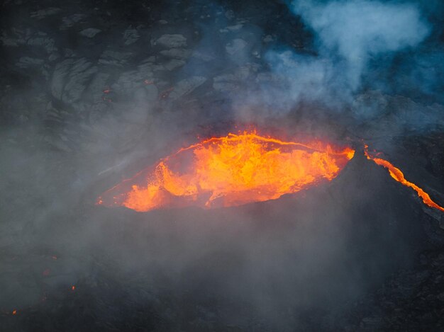 Vista única do vulcão em erupção e arredores fervendo lava vermelha quente fluindo puxar para longe drone