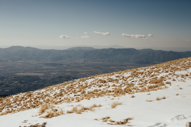 Una vista del valle con la ciudad vista desde la cima de la montaña nevada.