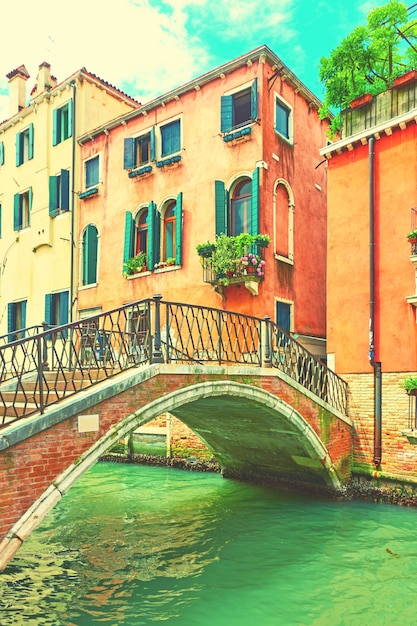 Vista veneciana con pequeño puente de arco y casas por canal, Venecia. Estilo vintage