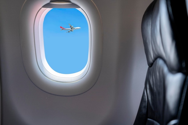 Vista de la ventana desde el asiento del pasajero en un avión comercial Hermosa vista desde la ventana del avión al cielo azul con pasajeros volando en la dirección opuesta
